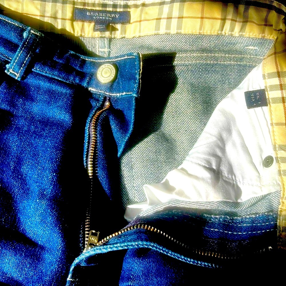 Burberry dark wash jeans with signature nova plaid cuffs for turn up hems.